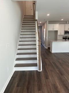 staircase featuring recessed lighting, baseboards, and wood finished floors