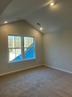 unfurnished room featuring baseboards, carpet floors, and vaulted ceiling