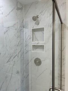 bathroom with a marble finish shower