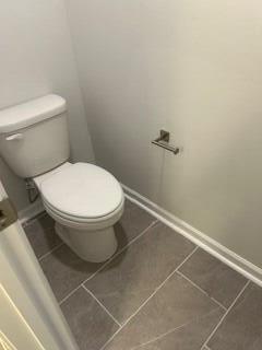 bathroom with tile patterned floors, toilet, and baseboards