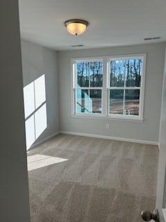 unfurnished room with visible vents, baseboards, and carpet floors