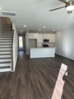 kitchen featuring visible vents, stainless steel microwave, dark wood-style floors, white cabinets, and light countertops