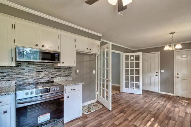 kitchen featuring light wood-type flooring, french doors, white cabinets, hanging light fixtures, and appliances with stainless steel finishes