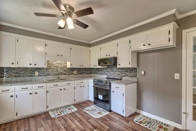 kitchen with light stone countertops, sink, ornamental molding, white cabinetry, and appliances with stainless steel finishes