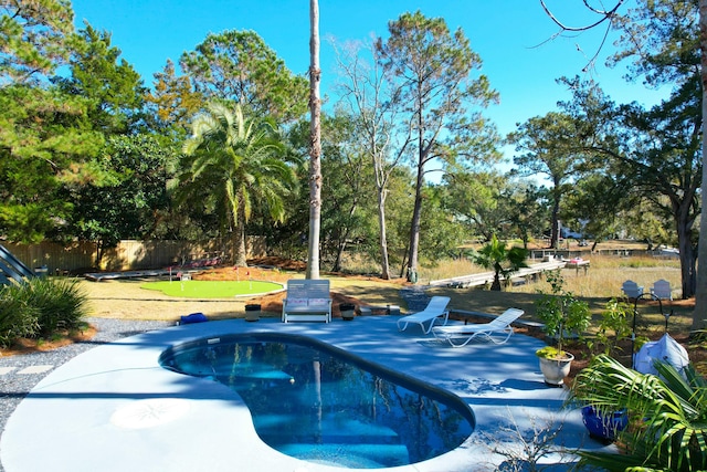 view of swimming pool featuring fence