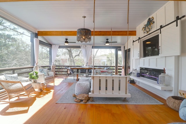 sunroom with lofted ceiling with beams and ceiling fan