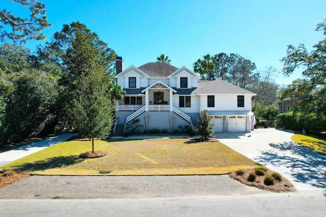 view of front facade with a garage, stairs, concrete driveway, and a front yard