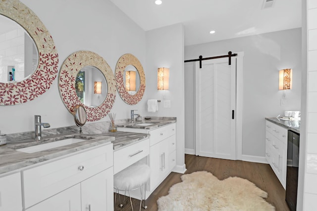 bathroom with recessed lighting, wood finished floors, visible vents, baseboards, and vanity