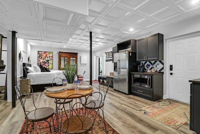 kitchen featuring stainless steel appliances, open floor plan, an ornate ceiling, and light wood-style flooring