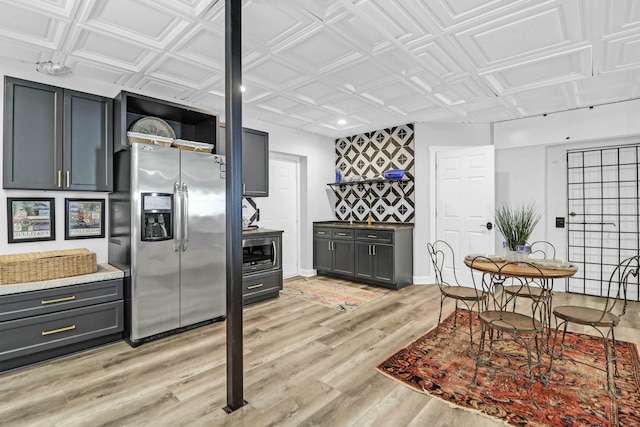 kitchen featuring appliances with stainless steel finishes, light wood-type flooring, an ornate ceiling, and gray cabinetry