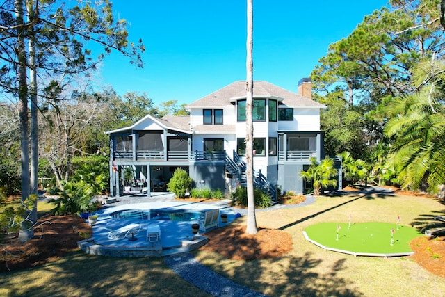 back of house with a patio, a chimney, a pool, stairway, and a sunroom