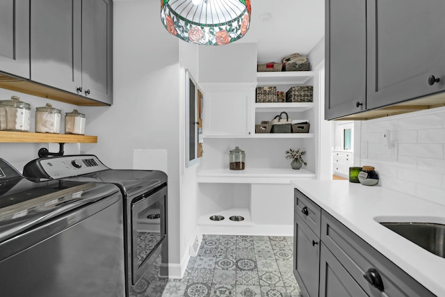 clothes washing area featuring cabinet space, light tile patterned floors, baseboards, and washer and clothes dryer