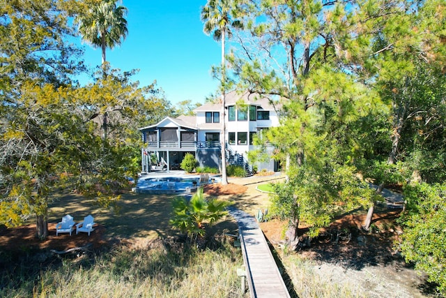 back of house featuring a balcony and a sunroom