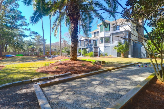 view of community featuring a lawn and stairway