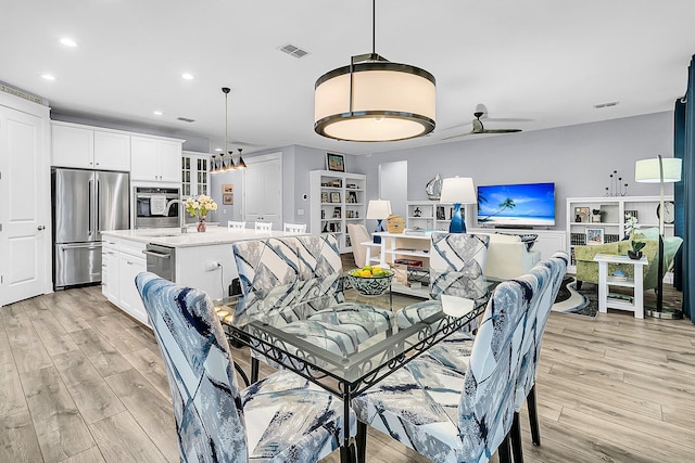 dining space featuring ceiling fan and light wood-type flooring