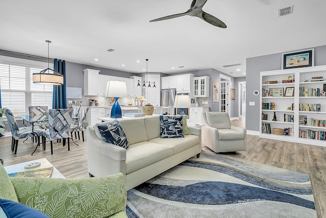 living room featuring ceiling fan and light hardwood / wood-style floors