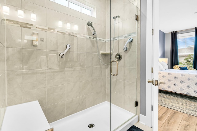 bathroom featuring hardwood / wood-style flooring and a shower with shower door