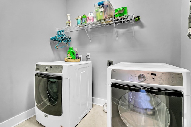 clothes washing area with washing machine and dryer and light tile patterned floors