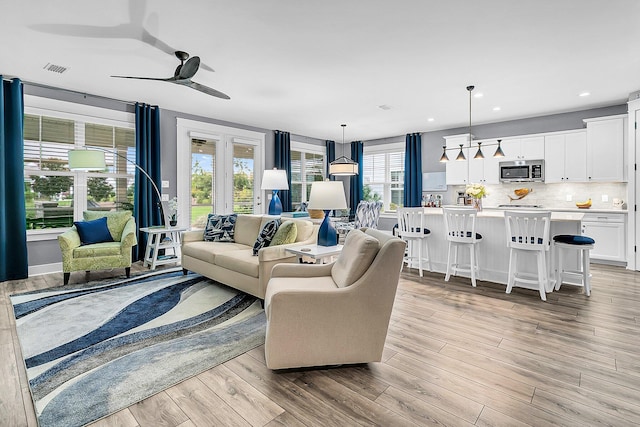 living room with ceiling fan and light hardwood / wood-style floors