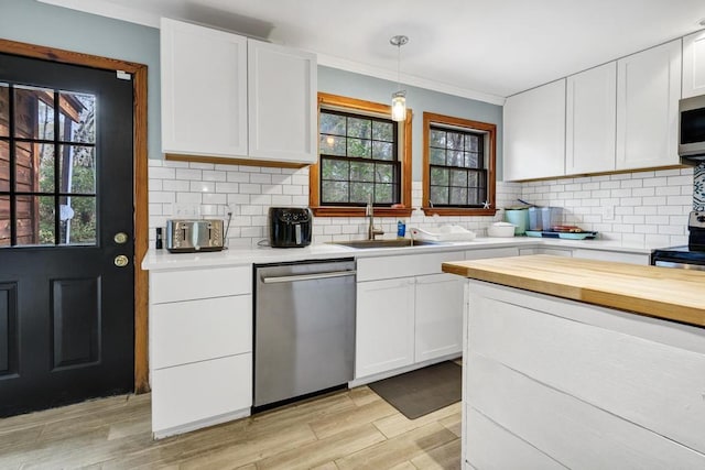 kitchen featuring wood counters, white cabinetry, appliances with stainless steel finishes, light wood finished floors, and tasteful backsplash