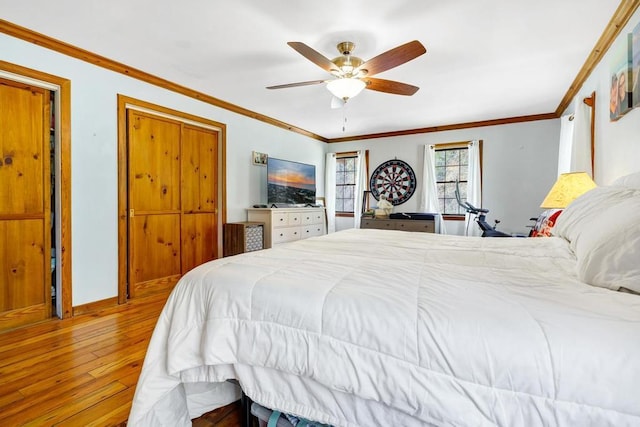 bedroom with ceiling fan, baseboards, hardwood / wood-style flooring, and crown molding