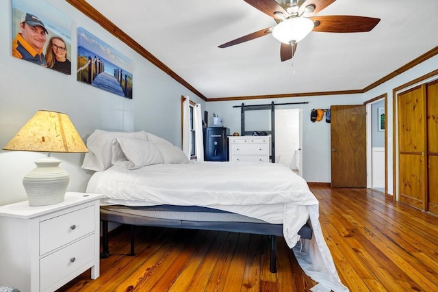 bedroom with hardwood / wood-style flooring, ceiling fan, baseboards, and crown molding