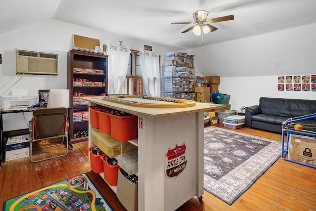 recreation room featuring ceiling fan, a wall mounted air conditioner, vaulted ceiling, and wood finished floors