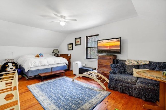 bedroom featuring a ceiling fan, vaulted ceiling, and wood finished floors