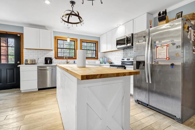 kitchen with white cabinets, butcher block counters, tasteful backsplash, and stainless steel appliances