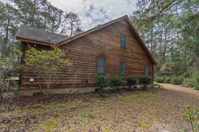 view of property exterior with roof with shingles