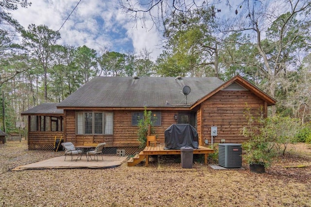 rear view of house with a deck, a patio, a sunroom, and central air condition unit