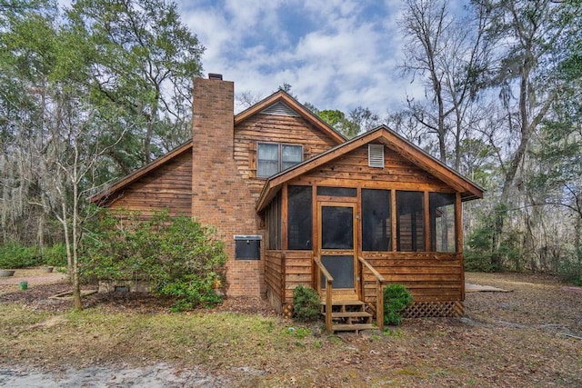 view of front facade with a chimney and a sunroom