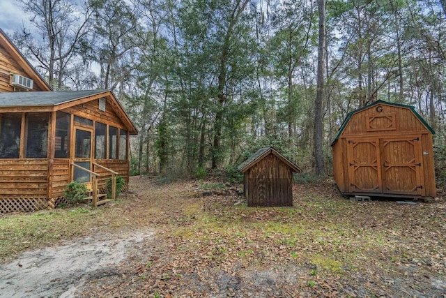 view of yard featuring a sunroom, a storage unit, and an outbuilding