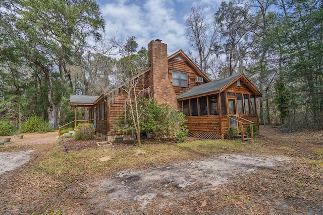 exterior space with a sunroom and a chimney