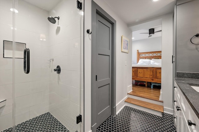 full bathroom with connected bathroom, baseboards, a stall shower, and vanity