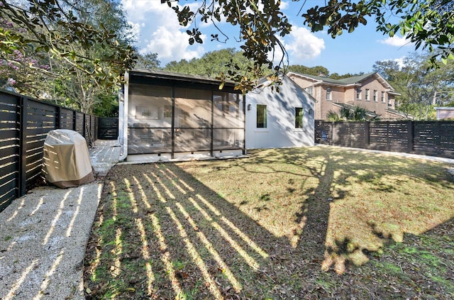 view of yard with a fenced backyard and a sunroom