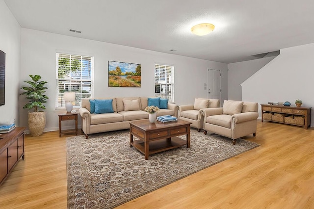 living room featuring plenty of natural light and light hardwood / wood-style flooring