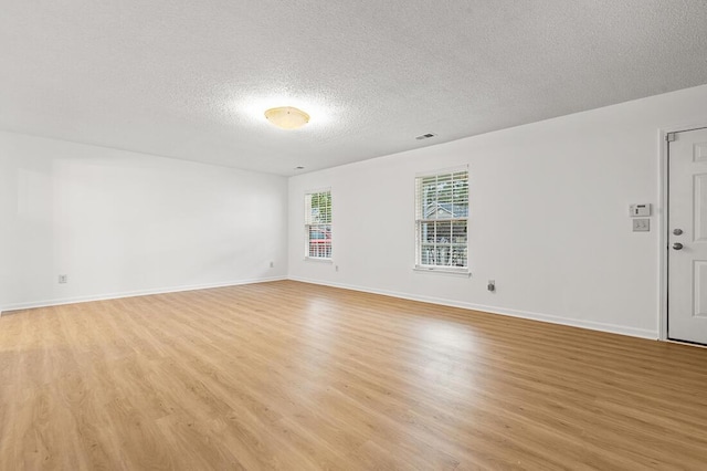 empty room featuring light hardwood / wood-style floors and a textured ceiling