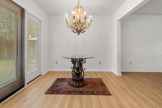 dining area featuring hardwood / wood-style flooring, a wealth of natural light, and a notable chandelier