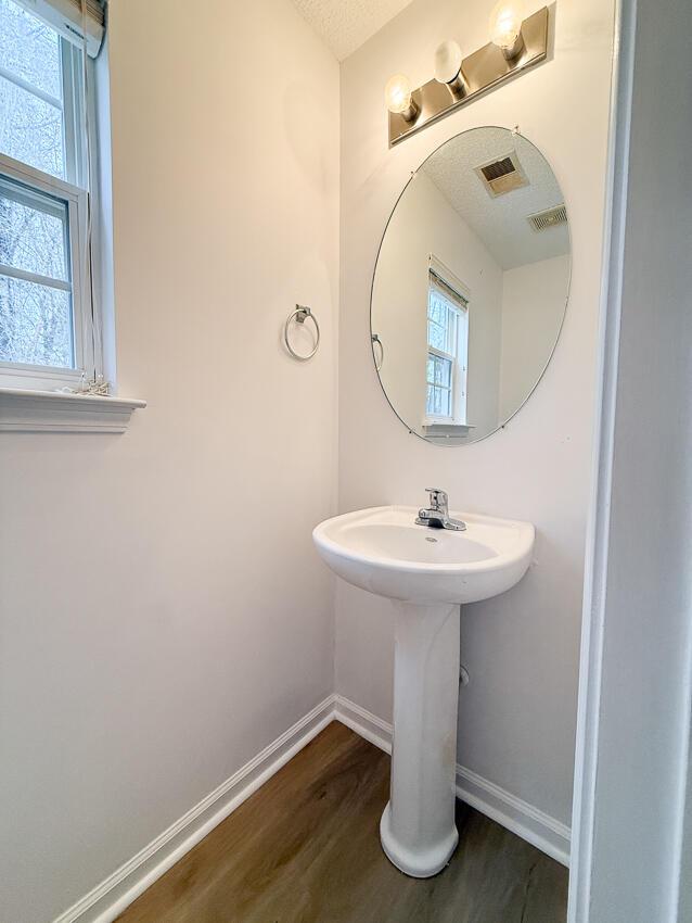 bathroom featuring hardwood / wood-style floors and a textured ceiling