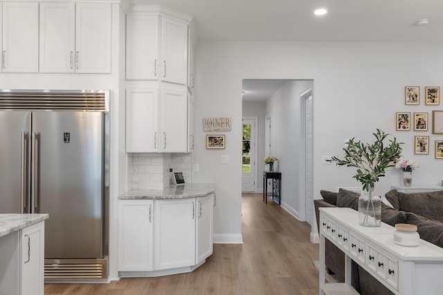 1130 Plantation Overlook Dr, Moncks Corner, SC 29461 - kitchen with built in fridge, light wood-style flooring, white cabinetry, recessed lighting, and light stone counters