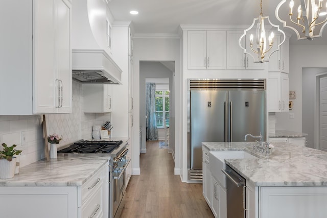 1130 Plantation Overlook Dr, Moncks Corner, SC 29461 - kitchen with premium appliances, custom range hood, a chandelier, white cabinetry, and light wood-style flooring