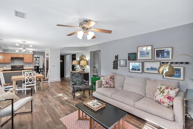 living room with ceiling fan, wood finished floors, visible vents, and baseboards