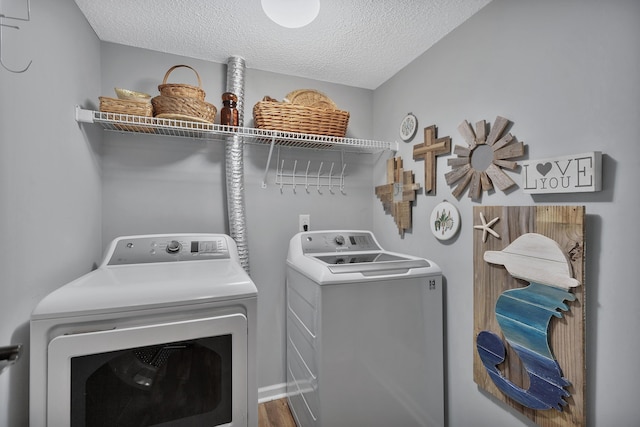 laundry area featuring washer and dryer, laundry area, and a textured ceiling