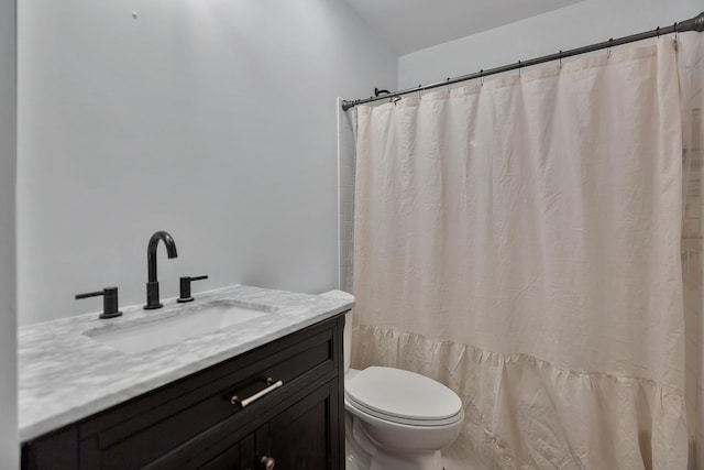 bathroom featuring toilet, vanity, and a shower with shower curtain