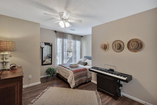 bedroom with a textured ceiling, wood finished floors, visible vents, and baseboards