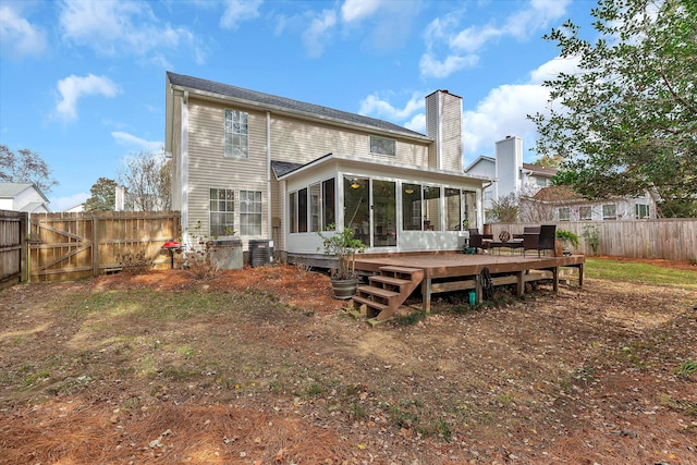 back of house featuring cooling unit, a fenced backyard, a sunroom, a wooden deck, and a chimney