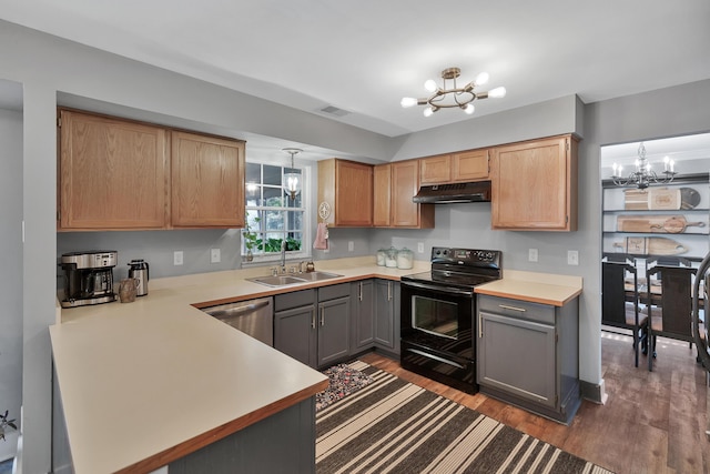 kitchen with a chandelier, under cabinet range hood, a sink, and electric range