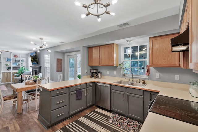 kitchen featuring a peninsula, a notable chandelier, range hood, stainless steel dishwasher, and a sink