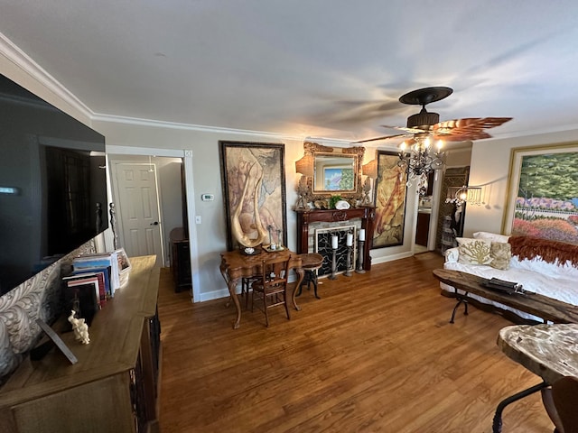 living room with ceiling fan, hardwood / wood-style flooring, crown molding, and a fireplace